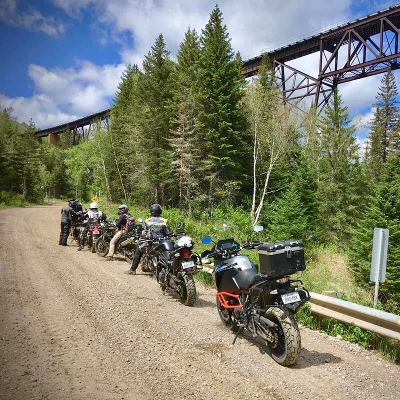 Group of adventure motorcycles next to a bridge: group motorcycle touring is about shared memories